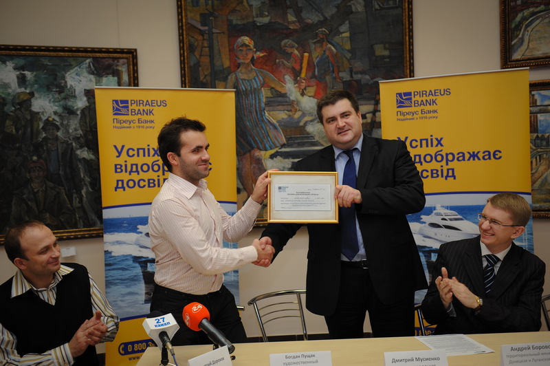 Дмитрий Мусиенко, член правления Пиреус Банка в Украине, передает чек на проведение благотворительной акции 